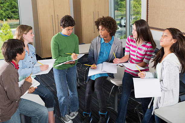 Students in classroom Multi-ethnic group of students in classroom, working together on a project. middle school discussion stock pictures, royalty-free photos & images