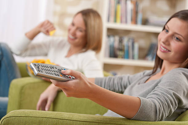 Students - Two female teenager watching television stock photo