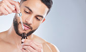 istock Studio shot of a handsome young man applying serum to his face against a grey background 1362840791