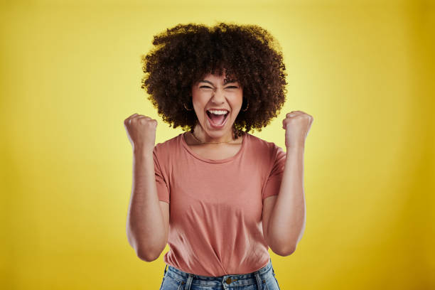 Studio shot of an attractive young woman looking excited against a yellow background When your moment comes, you won't forget it exhilaration stock pictures, royalty-free photos & images