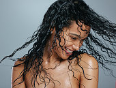 istock Studio shot of an attractive young woman tossing her wet hair against a grey background 1344963254