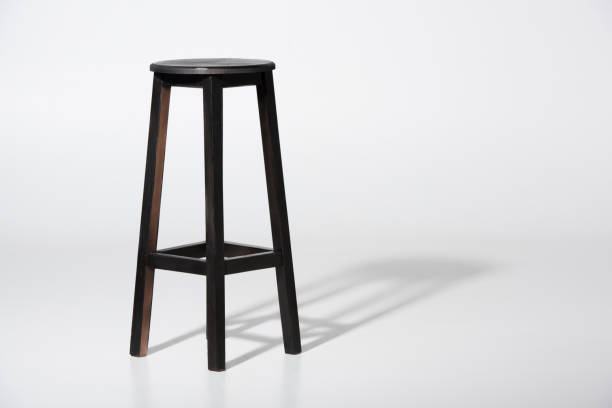 Studio shot of classic black tall wooden barstool standing on white Studio shot of classic black tall wooden barstool standing on white stool stock pictures, royalty-free photos & images