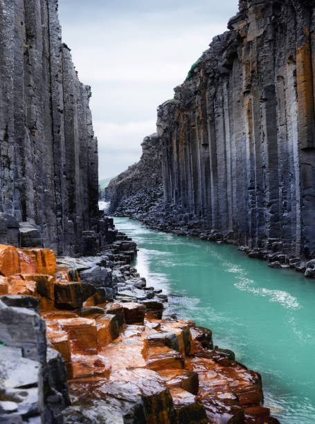Studlagil basalt canyon in Iceland. Most famous and popular place in Iceland. River in canyon. Nature in Iceland Studlagil basalt canyon in Iceland. Most famous and popular place in Iceland. River in canyon. Nature in Iceland basalt column stock pictures, royalty-free photos & images