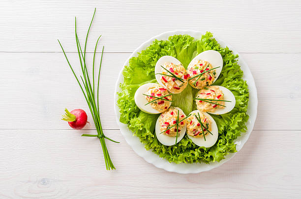 Stuffed eggs on lettuce with chives garnish stock photo