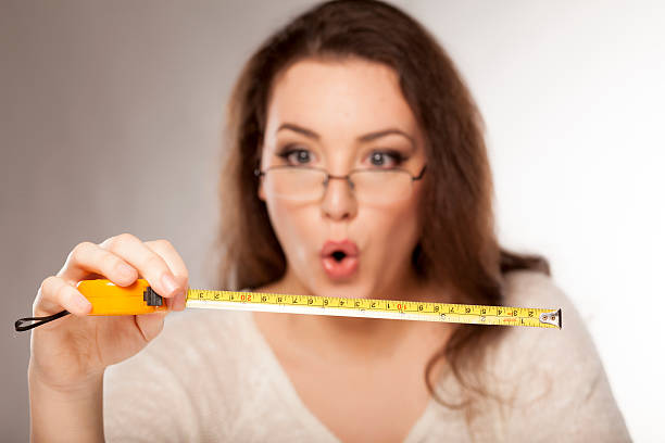 stunned by the size young woman is stunned by the size shown on the measuring tape human mouth gag adhesive tape women stock pictures, royalty-free photos & images