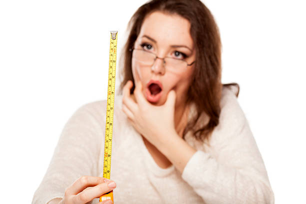 stunned by the size young woman is stunned by the size shown on the measuring tape human mouth gag adhesive tape women stock pictures, royalty-free photos & images