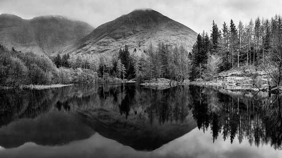 Beautiful  black and white landscape image of Torren Lochan in Glencoe in Scottish Highlands on a Winter day