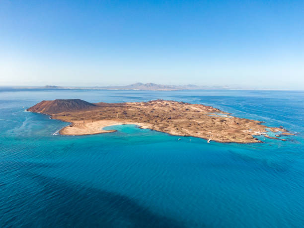 Stunning high angle panoramic aerial drone view of Isla de Lobos, a small uninhabited island just 2 kilometres off the coast of Fuerteventura, Canary Islands, Spain. Lanzarote in the background. stock photo