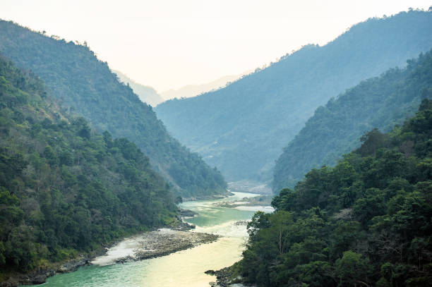 Stunning view of some green mountain peaks with the Sacred Ganges River flowing between them in Rishikesh, India. Stunning view of some green mountain peaks with the Sacred Ganges River flowing between them in Rishikesh, India. ganges river stock pictures, royalty-free photos & images