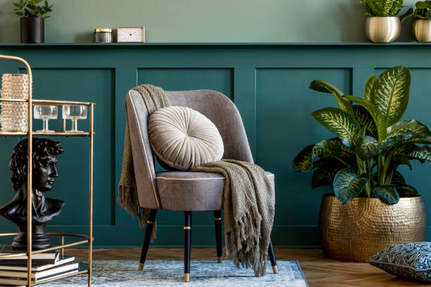 디자인 회색 안락 의자, 금 주류 캐비닛, 식물과 우아한 개인 액세서리와 거실의 세련되고 현대적인 구성. 선반이있는 회색 벽 패널. 현대적인 홈 장식. 템플릿. - 실내 장식 뉴스 사진 이미지