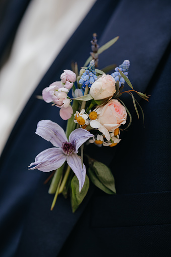 stylish boutonniere on groom's jacket, wedding day, beautiful flower blossom and bride boutonniere, wedding concept