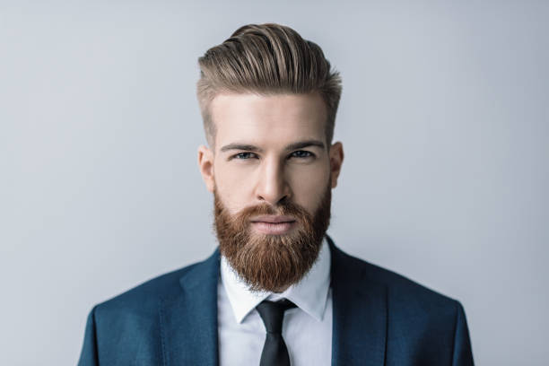 Stylish handsome bearded businessman looking at camera Stylish handsome bearded businessman looking at camera beard stock pictures, royalty-free photos & images