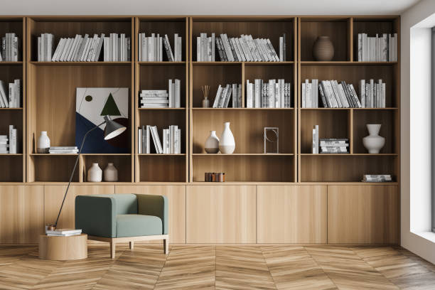 Stylish modern interior of contemporary library with comfortable armchair. Book with bookshelf. Wooden parquet floor. stock photo