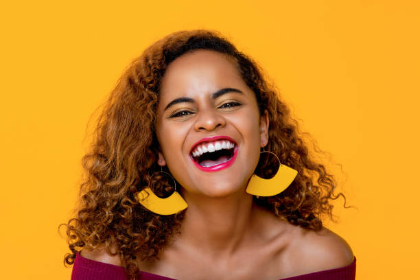 Stylish pretty African american woman laughing  in isolated yellow background stock photo