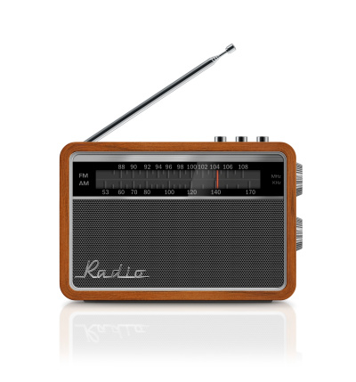 Front view of stylish, retro, portable transistor radio which received FM and AM bands. Radio has a wooden body, analog display, honeycomb speaker grille with metallic buttons, antenna and 