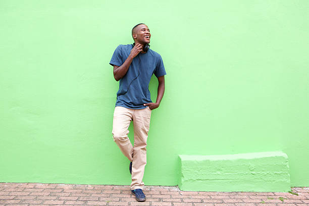 Stylish young african man looking at copy space Full length portrait of stylish young african man standing against a green wall and looking away 20 29 years photos stock pictures, royalty-free photos & images