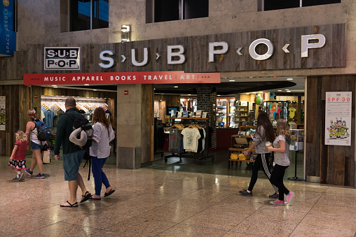 Seattle, USA - Jul, 9, 2018: People passing the Sub Pop shop in the Seatac airport late in the day. Sub Pop is the famous music label that brought Grunge music  to Seattle.