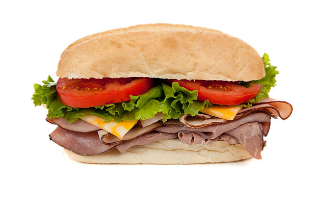 Submarine sandwich on white A submarine sandwich with ham, turkey, roast beef,  lettuce, tomato and swiss cheese on a white background roast beef sandwich stock pictures, royalty-free photos & images