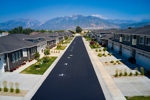 An aerial view of a USA suburban neighborhood with freshly coated pavement on the roads.