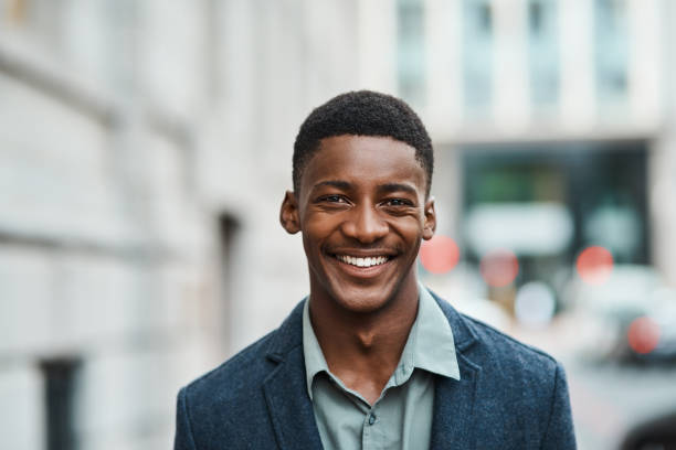 Success happens the moment you believe it will Portrait of a confident young businessman standing against an urban background headshot stock pictures, royalty-free photos & images