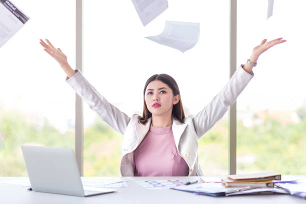 success young female manager, business woman throw working document on in office with view of computer laptop and graph document stock photo