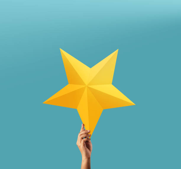 Successful and Talent Concept, Hand Raise up a Golden Star into the blue Sky stock photo
