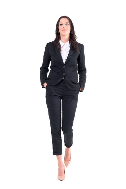 Successful female business manager or lawyer walking with hands in pockets. Successful female business manager or lawyer walking with hands in pockets. Full body isolated on white background. approaching stock pictures, royalty-free photos & images