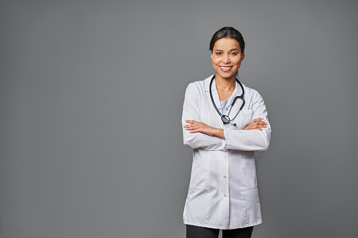 Successful female doctor isolated on grey background