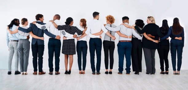 Successful teamwork means always having others by your side Rearview shot of a group of businesspeople standing together with their arms around each other arm around stock pictures, royalty-free photos & images