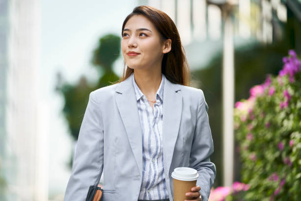 successful young asian business woman office worker walking on street stock photo