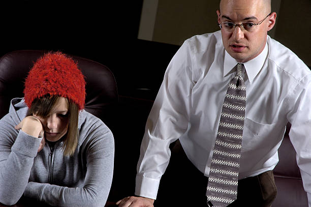 Sulking girl with red hat sitting near man in business suit stock photo