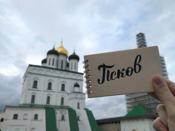 Summer day in Pskov. View to the Kremlin and Trinity Cathedral with calligraphic inscription "Pskov" in russian on notebook. Pskov, Russia, Jule 30, 2021. Fokus on notebook. Mobile photography. Summer day in Pskov. View to the Kremlin and Trinity Cathedral with calligraphic inscription "Pskov" in russian on notebook. Pskov, Russia, Jule 30, 2021. Fokus on notebook. Mobile photography. pskov russia stock pictures, royalty-free photos & images