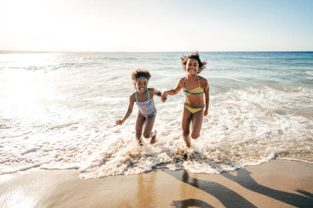 Summer fun Happy girls on the beach little girls in bathing suits stock pictures, royalty-free photos & images