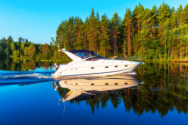Summer in Finland Scenic summer view of recreational yacht sailing by the lake water landscape among islands with deep forests in Finland motorboat stock pictures, royalty-free photos & images