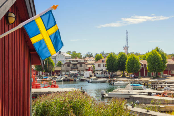 Summer in Stockholm archipelago A swedish flag by the harbor in the village of Sandhamn on Sandön (island) in Stockholm archipelago. swedish flag photos stock pictures, royalty-free photos & images
