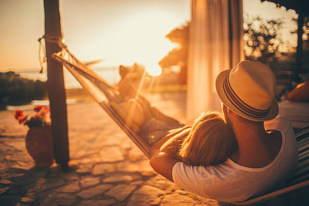 Summer love Young couple enjoy their love on sunset, while lying down in a hammock on their vacation in beautiful Greece casual  relationship stock pictures, royalty-free photos & images