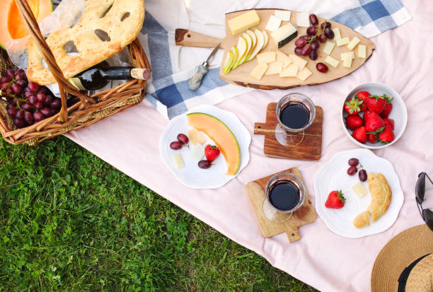 Summer picnic with cheese, wine, fruits and bread. Picnic at the park. Summer picnic with cheese, wine, fruits and bread. Picnic at the park, flat lay, copy space. picnic stock pictures, royalty-free photos & images