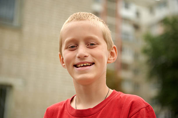 Summer, ten-year boy, red shirt, smiling, outdoors. stock photo