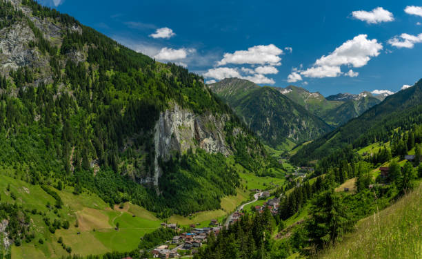 Summer valley with Grossarler Ache small river and blue cloudy sky stock photo