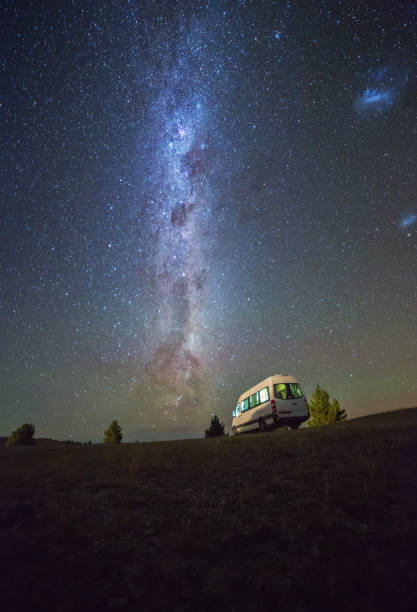 Summertime view of Milky way and night sky with camper van at South island New Zealand stock photo