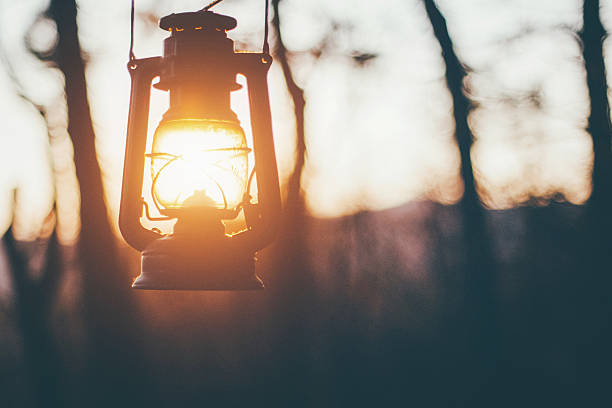 Sun captured in old lantern Old lantern hanging in forest, sun shining insted of fire lantern stock pictures, royalty-free photos & images