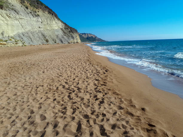 Sun golden sand cliffs and turquoise sea on beach Marathias Corfu Greece stock photo