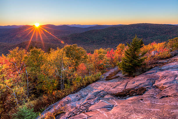 Sun Setting Behind Seneca Mountain Colorful Autumn Sunset over Seneca Mountain from an overlook on Hadley Mountain in the Adirondack Mountains of New York adirondack state park stock pictures, royalty-free photos & images