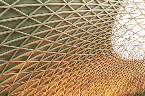 Sun shines through the triangulated roof at Kings Cross Station in London, United Kingdom
