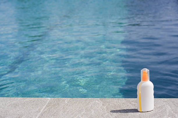 Sun tan lotion poolside stock photo