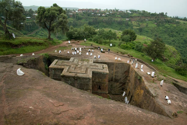 Sunday at St George rock hewn church LALIBELA, ETHIOPIA - 26 AUGUST 2007 - Pilgrims gather at the top of a rock hewn church to pray on a sunday. Although services are carried out through out Lalibela each day, Sundays turn out the greatest local crowds. Many of these pilgrims have relocated to lalibela due to its religious roots. coptic christianity stock pictures, royalty-free photos & images