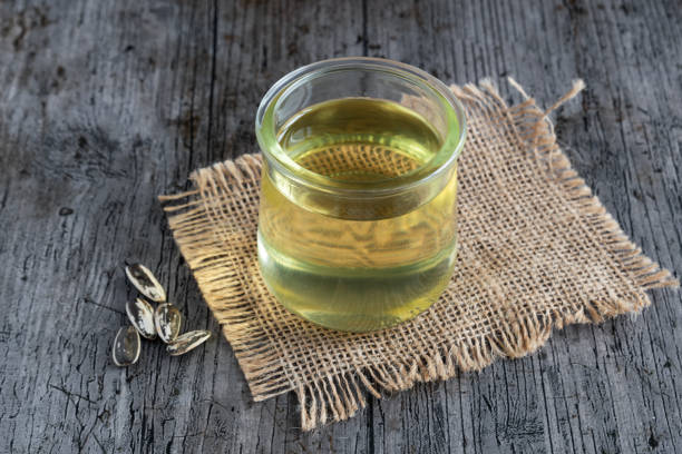 Sunflower oil in a transparent glass on a rustic background stock photo