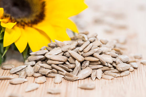 hướng dương với hạt giống trên gỗ - sunflower seeds hình ảnh sẵn có, bức ảnh & hình ảnh trả phí bản quyền một lần