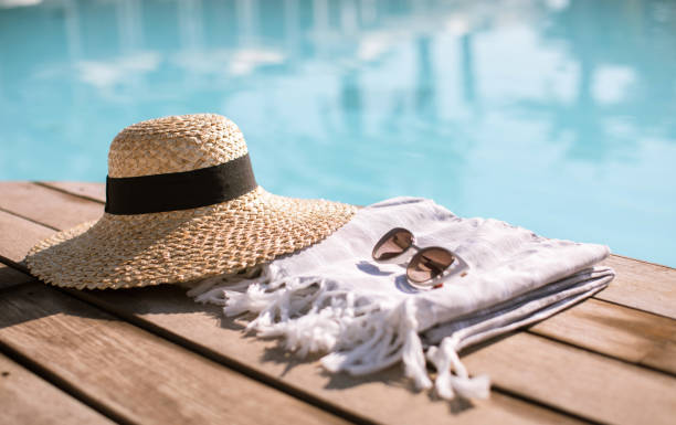 Sunglasses and straw hat Sunglasses and straw hat on the wooden floor at the pool. Summer Vacation Fashion Concept. still life stock pictures, royalty-free photos & images