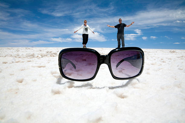 illusione divertente occhiali da sole: salt flats, bolivia - forced perspective foto e immagini stock